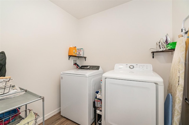 laundry area featuring washer and dryer and light hardwood / wood-style flooring