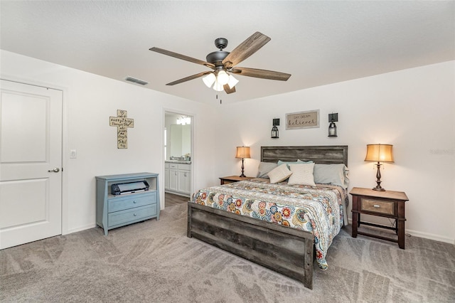 carpeted bedroom featuring ensuite bathroom and ceiling fan