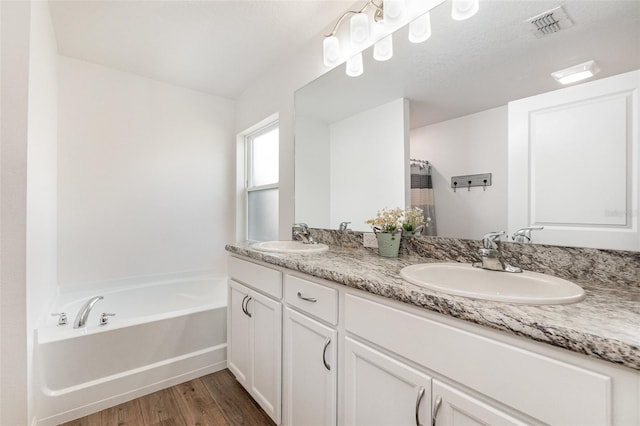 bathroom with a bathtub, wood-type flooring, and vanity