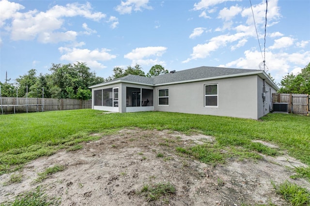 rear view of house with a yard and a sunroom