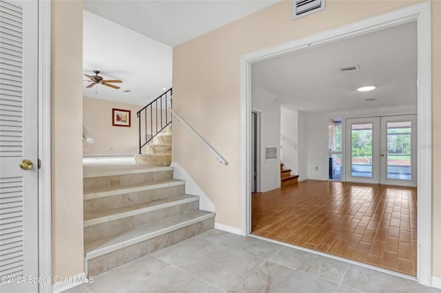 stairs featuring ceiling fan and french doors