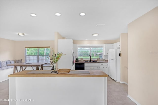 kitchen featuring white cabinets, dishwasher, white fridge, and sink