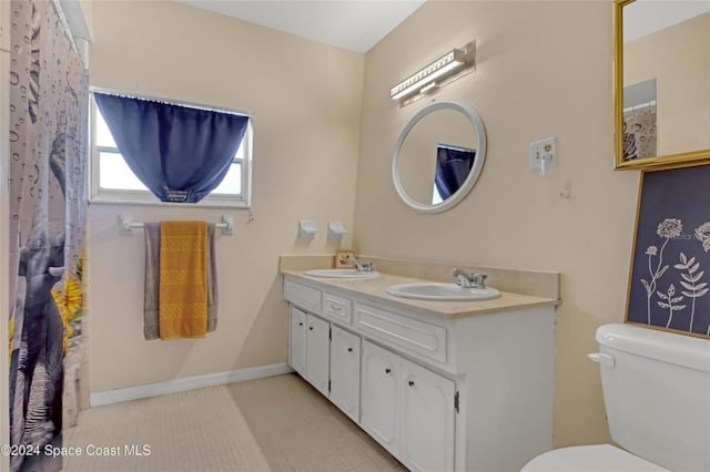 bathroom with tile patterned flooring, vanity, and toilet