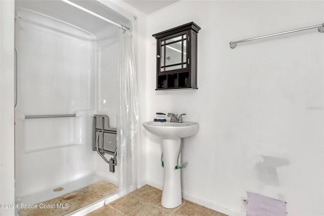 bathroom with a shower with shower curtain and tile patterned floors