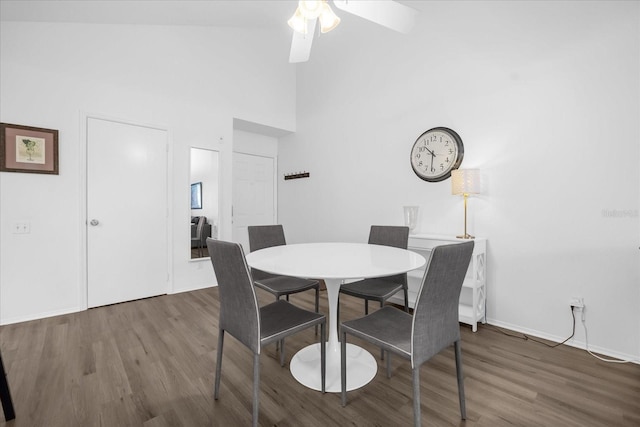 dining room featuring a towering ceiling, dark hardwood / wood-style floors, and ceiling fan