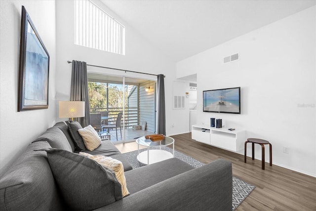 living room featuring dark hardwood / wood-style flooring and high vaulted ceiling