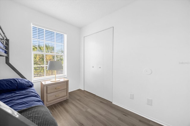 bedroom featuring hardwood / wood-style floors, a textured ceiling, and a closet