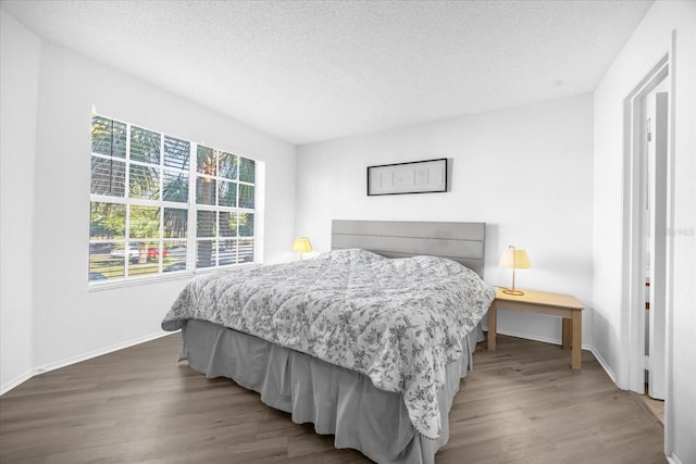 bedroom featuring a textured ceiling and dark wood-type flooring