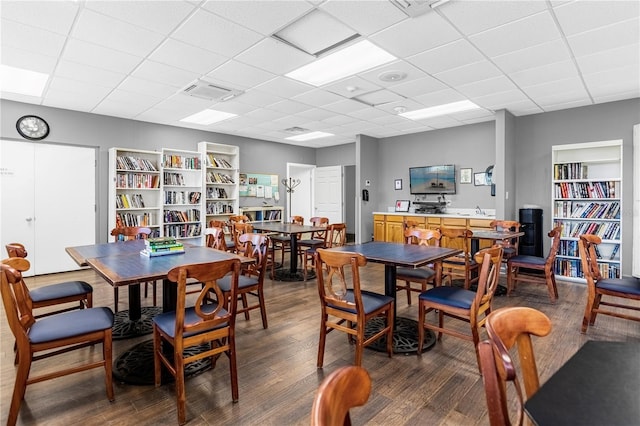 dining room with a paneled ceiling and dark hardwood / wood-style flooring