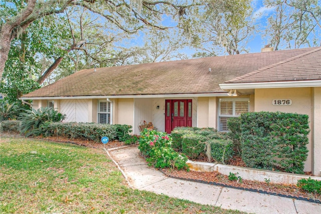 single story home with a front lawn and french doors