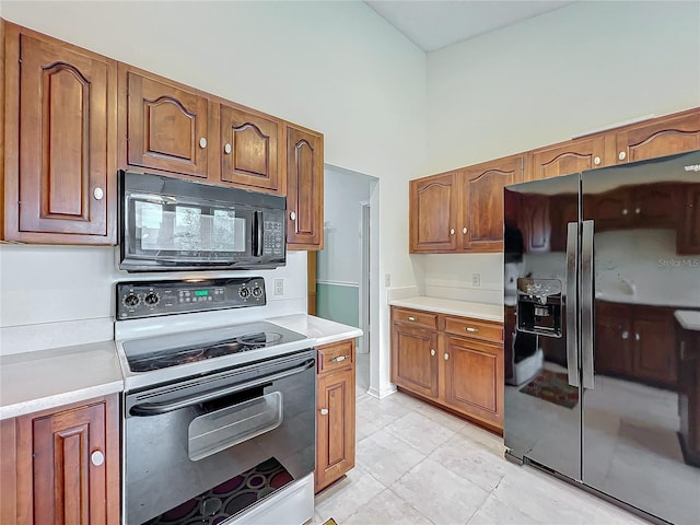 kitchen featuring black appliances and a high ceiling