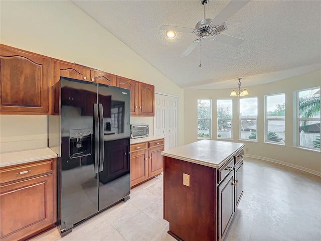 kitchen with black refrigerator with ice dispenser, pendant lighting, vaulted ceiling, a kitchen island, and ceiling fan with notable chandelier