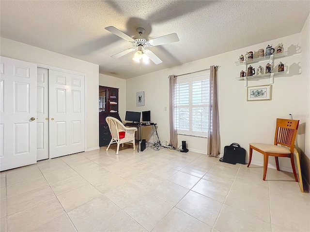 home office with a textured ceiling, ceiling fan, and light tile patterned flooring