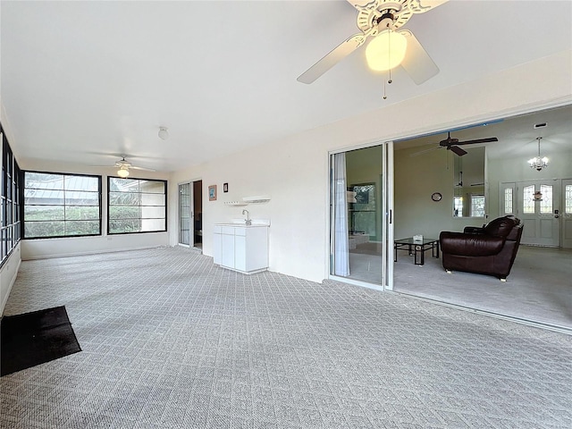 unfurnished sunroom featuring french doors, ceiling fan with notable chandelier, and sink