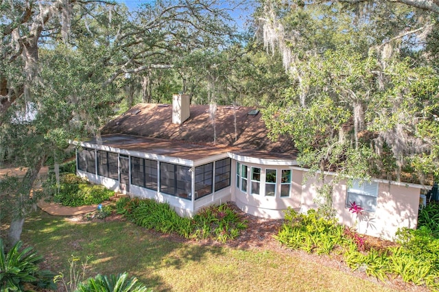 rear view of house with a sunroom and a yard