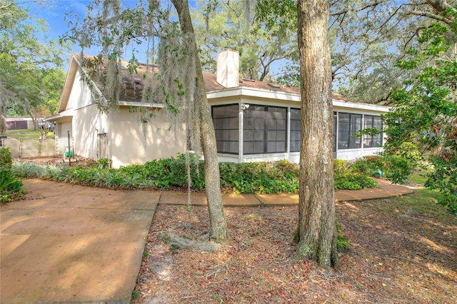 view of home's exterior with a sunroom