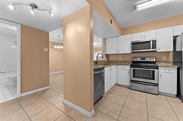 kitchen featuring white cabinets, stainless steel appliances, light tile patterned flooring, and sink