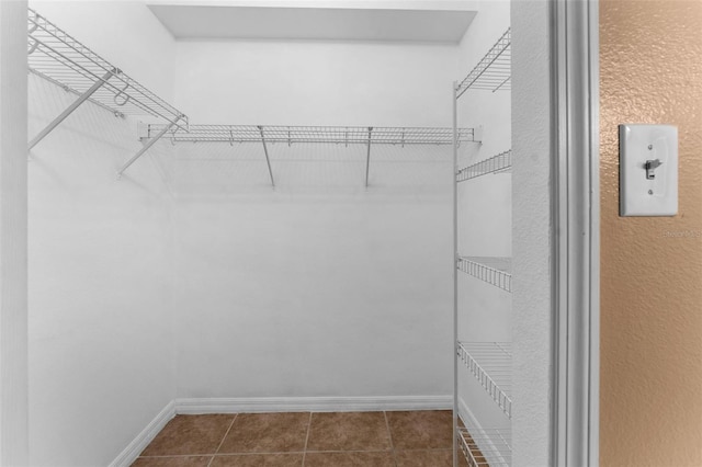 spacious closet featuring dark tile patterned flooring