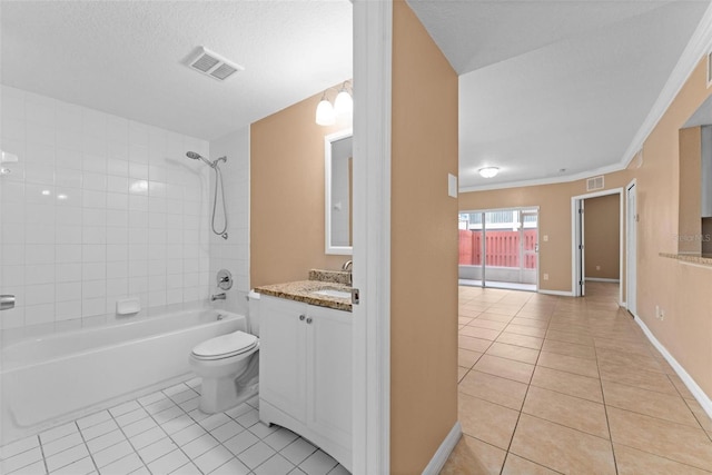 full bathroom with tile patterned flooring, vanity, tiled shower / bath combo, and toilet