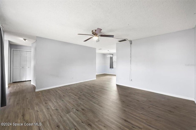 empty room with a textured ceiling, ceiling fan, and dark hardwood / wood-style floors