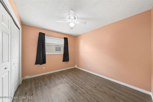 unfurnished bedroom featuring dark hardwood / wood-style flooring, ceiling fan, a closet, and a textured ceiling