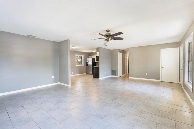 spare room with ceiling fan and light tile patterned floors