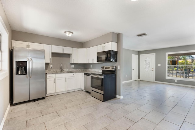 kitchen featuring white cabinets, light stone counters, sink, and stainless steel appliances