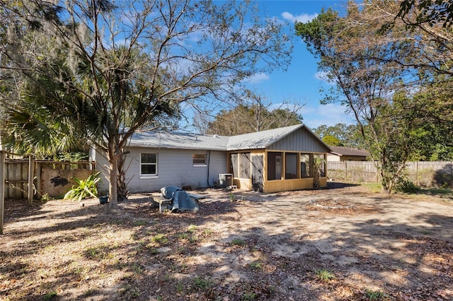 rear view of house featuring a sunroom