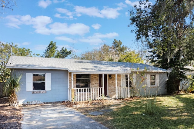 ranch-style house with a porch and a front yard