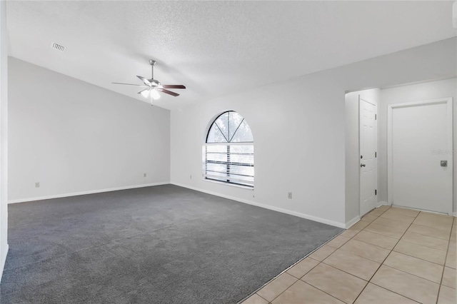 carpeted spare room featuring ceiling fan and a textured ceiling