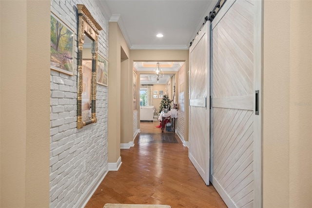 hallway featuring hardwood / wood-style floors, a barn door, and ornamental molding