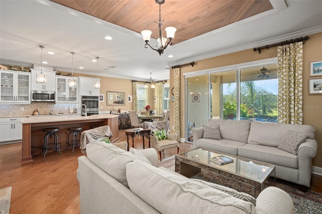 living room with a healthy amount of sunlight, light hardwood / wood-style floors, wooden ceiling, and crown molding