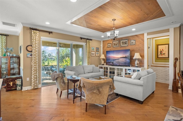 living room with a tray ceiling, crown molding, wood ceiling, and a notable chandelier