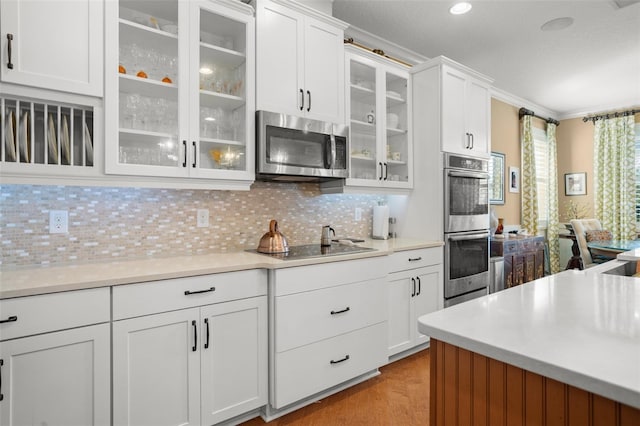 kitchen featuring tasteful backsplash, stainless steel appliances, crown molding, light hardwood / wood-style flooring, and white cabinets