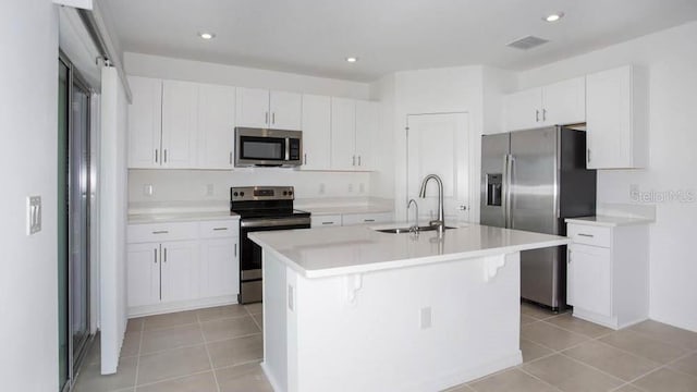 kitchen featuring white cabinetry, sink, a center island with sink, and appliances with stainless steel finishes