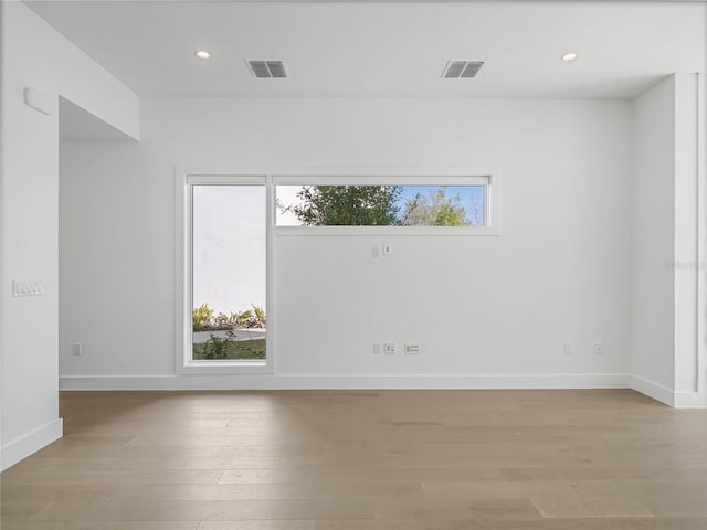 spare room with a wealth of natural light and light hardwood / wood-style floors