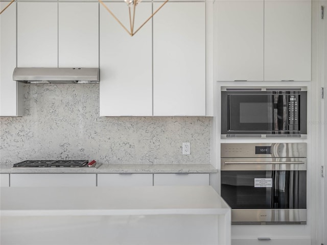 kitchen featuring appliances with stainless steel finishes, backsplash, and white cabinetry