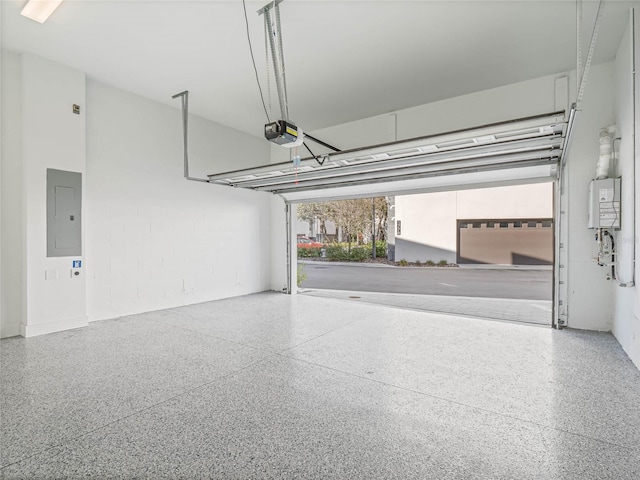 garage featuring electric panel, water heater, and a garage door opener