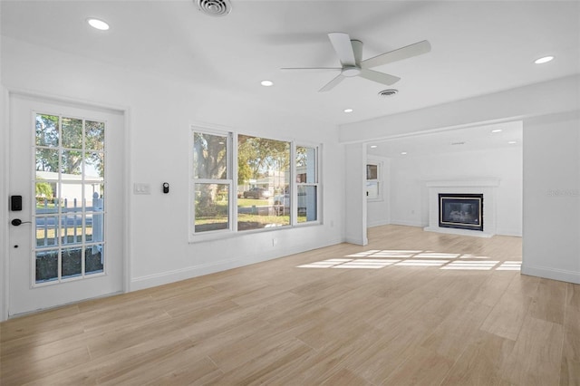 unfurnished living room with a fireplace, light hardwood / wood-style floors, and ceiling fan