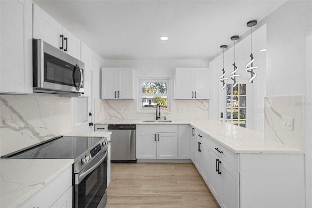 kitchen featuring pendant lighting, sink, white cabinetry, and stainless steel appliances