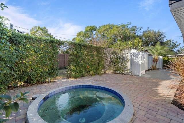 view of swimming pool featuring a patio area and an in ground hot tub