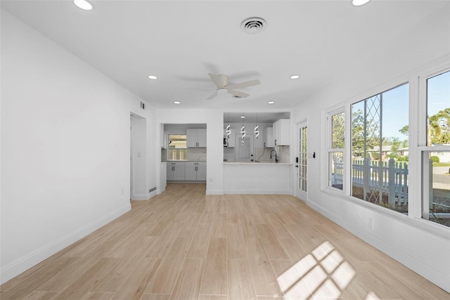 unfurnished living room featuring ceiling fan and light hardwood / wood-style flooring