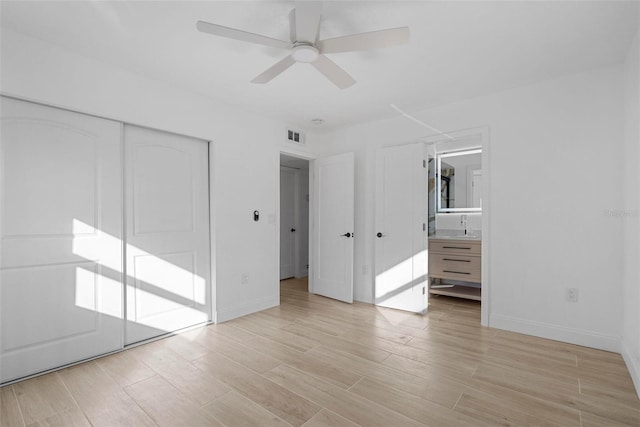 unfurnished bedroom with sink, ceiling fan, connected bathroom, light hardwood / wood-style floors, and a closet