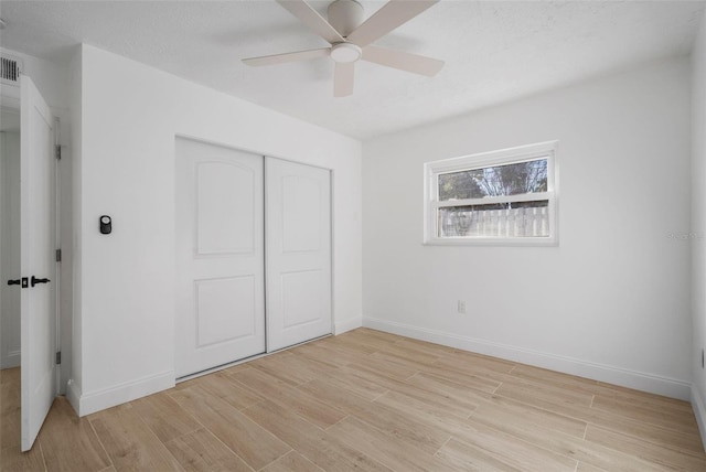 unfurnished bedroom featuring ceiling fan, light hardwood / wood-style flooring, and a closet