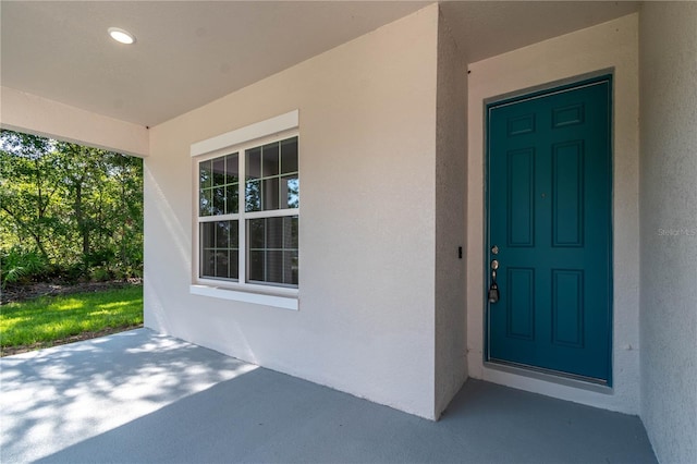 view of exterior entry featuring stucco siding