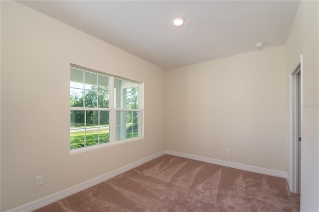 carpeted spare room with baseboards