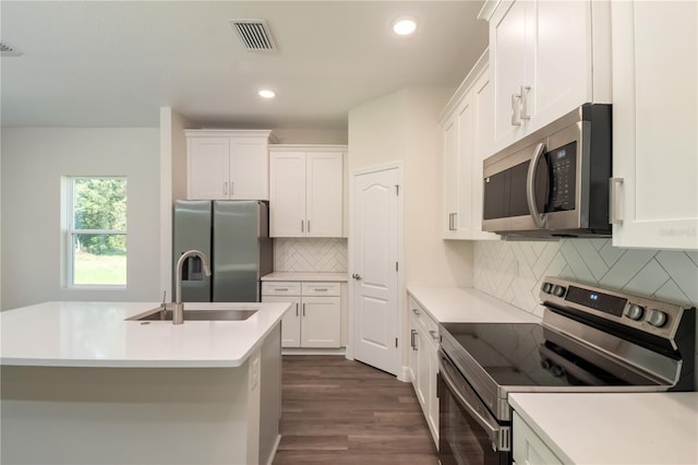 kitchen with a sink, stainless steel appliances, light countertops, and white cabinets