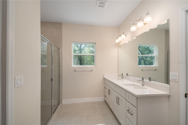 bathroom featuring double vanity, a stall shower, visible vents, and a sink