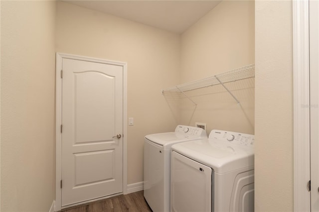 laundry area featuring laundry area, baseboards, dark wood-type flooring, and independent washer and dryer