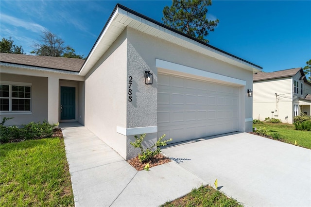 exterior space with a garage, driveway, and stucco siding